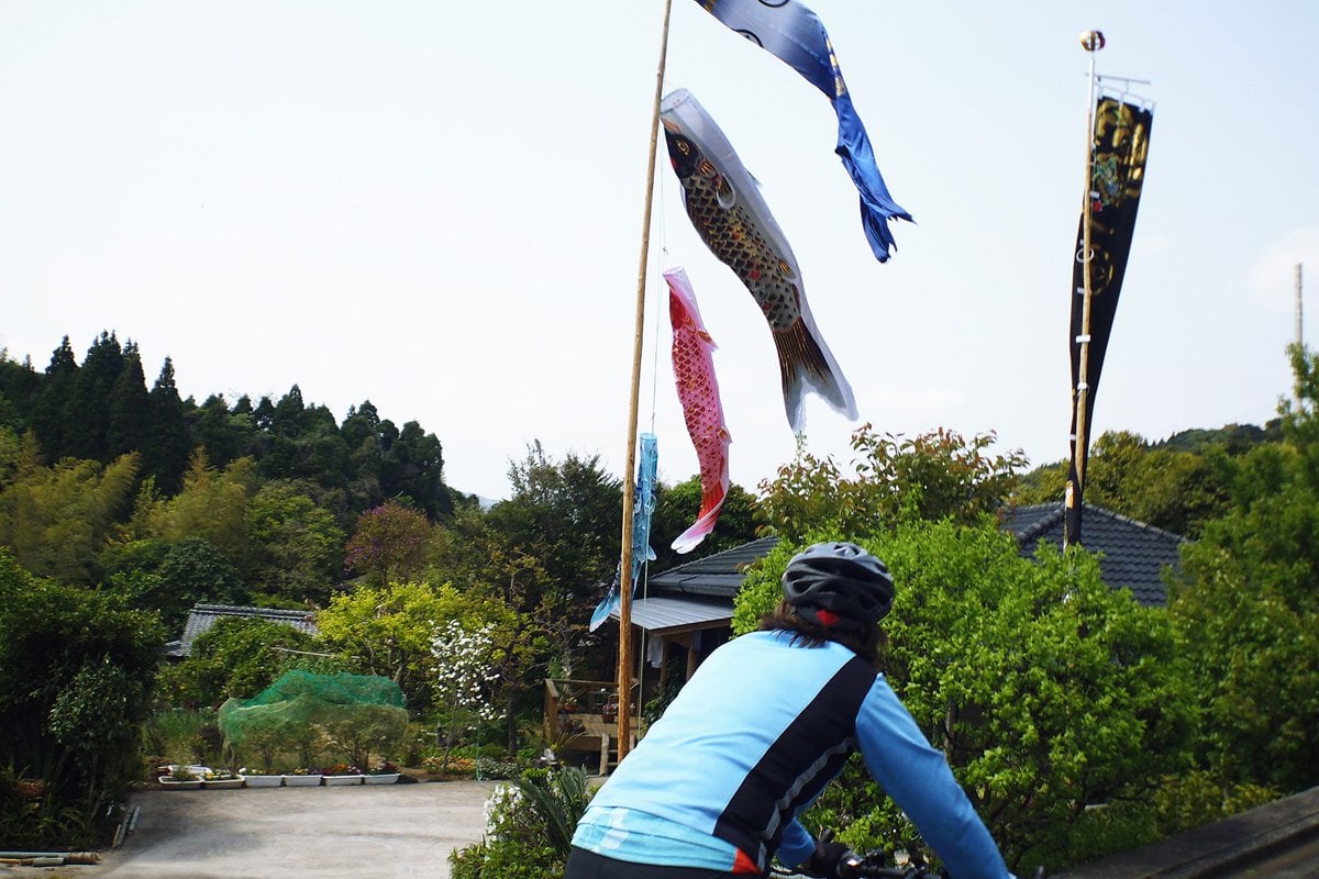 Cyclists in a village with a festival in Japan