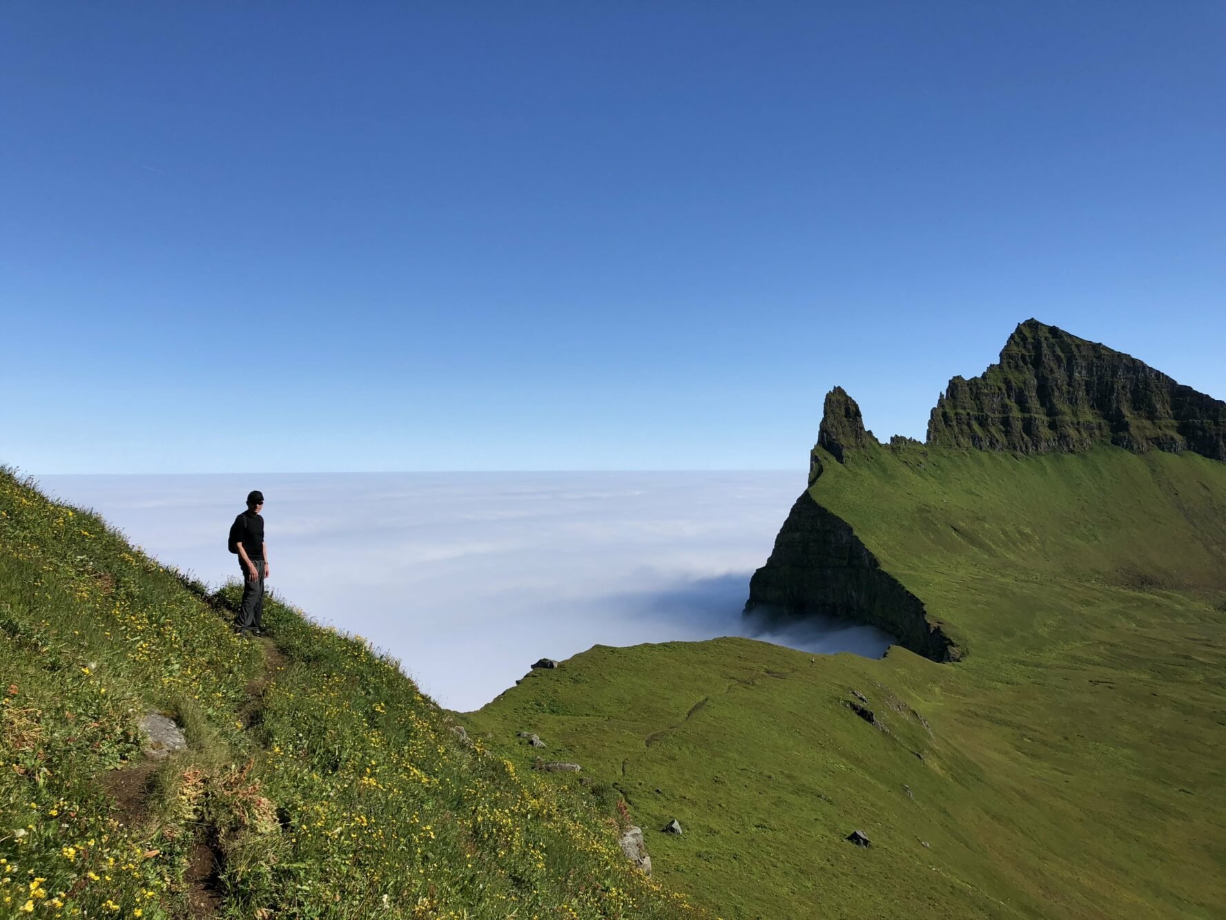 A person walking on a ridge in Greenland and enjoying the vista