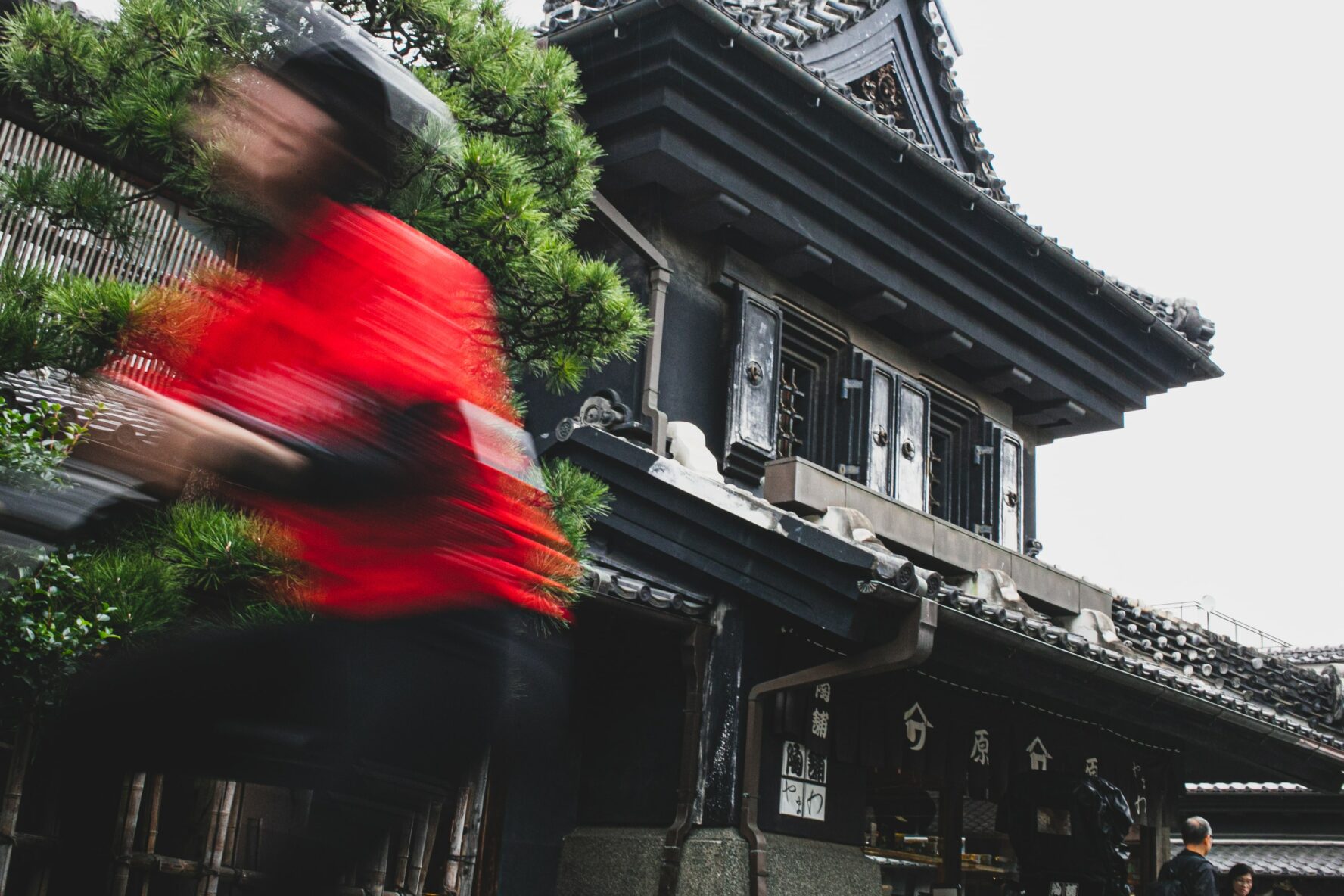 A biker speeding near a temple in Kyoto, Japan