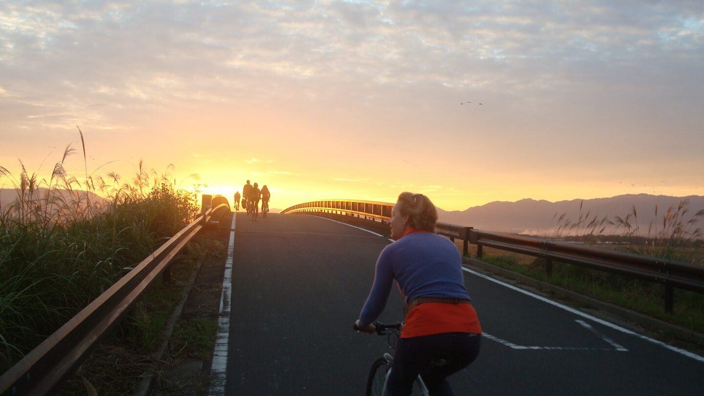 Cyclists on a road at sunset in Kyushu, Japan