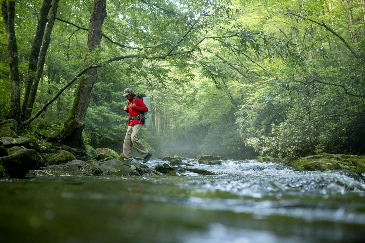 Hiker crossing stream in the Smoky Mountains