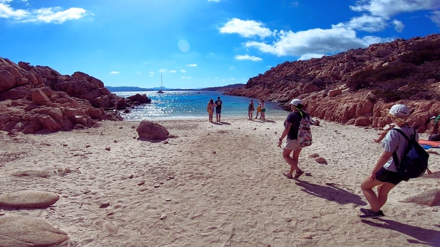 Sandy beach and hikers in Sardinia