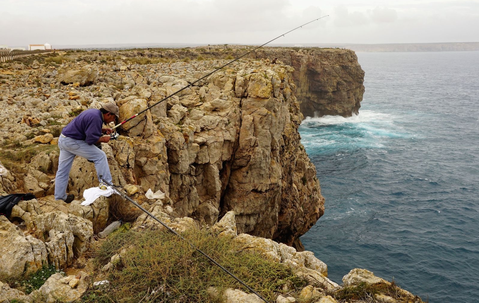 A fisherman casts his line from a rocky cliff in southwest Portugal