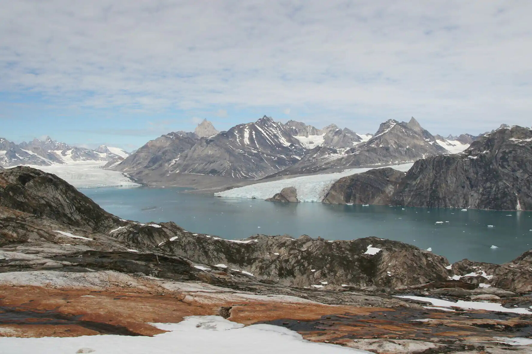 Glacier-filled fjord surrounded by snow-capped mountains