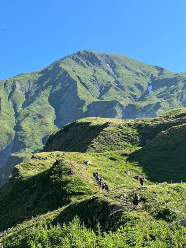 group hikers descending alps