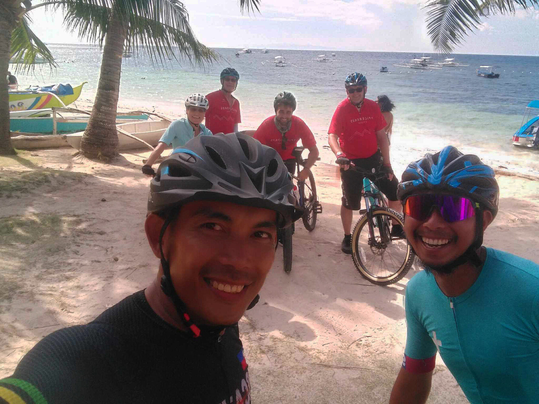 Selfie of a group of cyclists on a beach in the Philippines