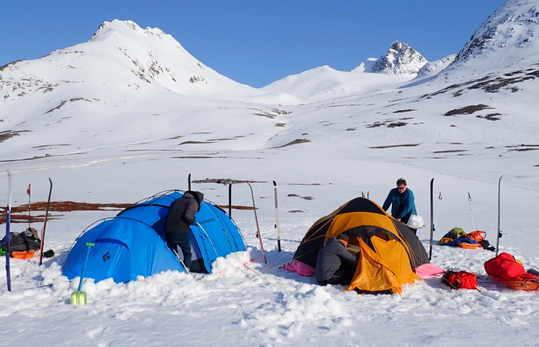 Skiers camping in a snowy mountain landscape in East Greenland