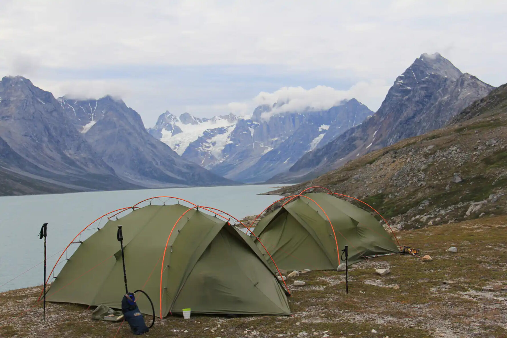 Two green tents pitched near a lake in Greenland