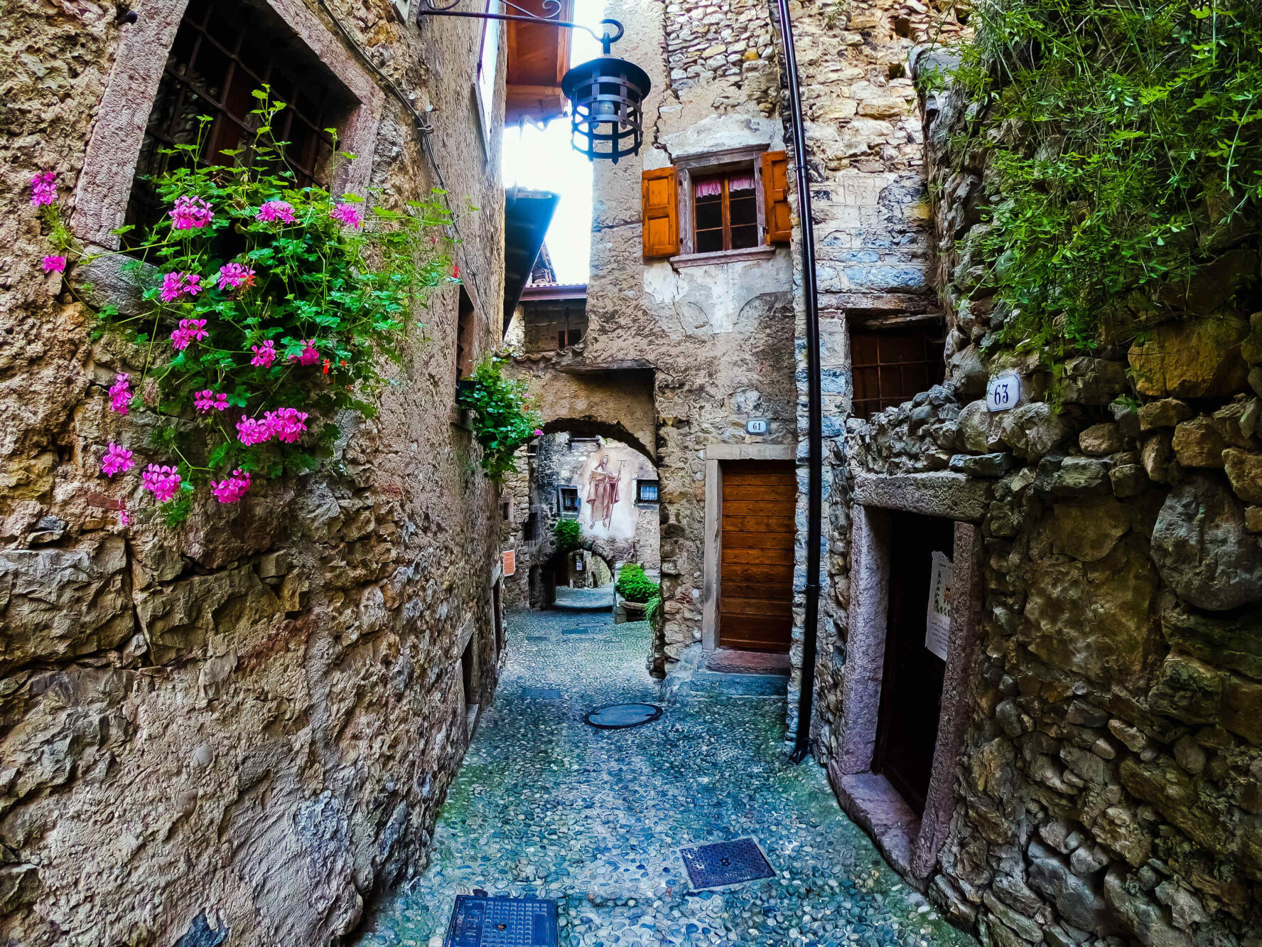 Charming cobblestone alley with old stone buildings in Canale di Tenno