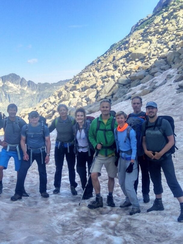 Hikers resting on rocky mountain terrain under a cloudy sky