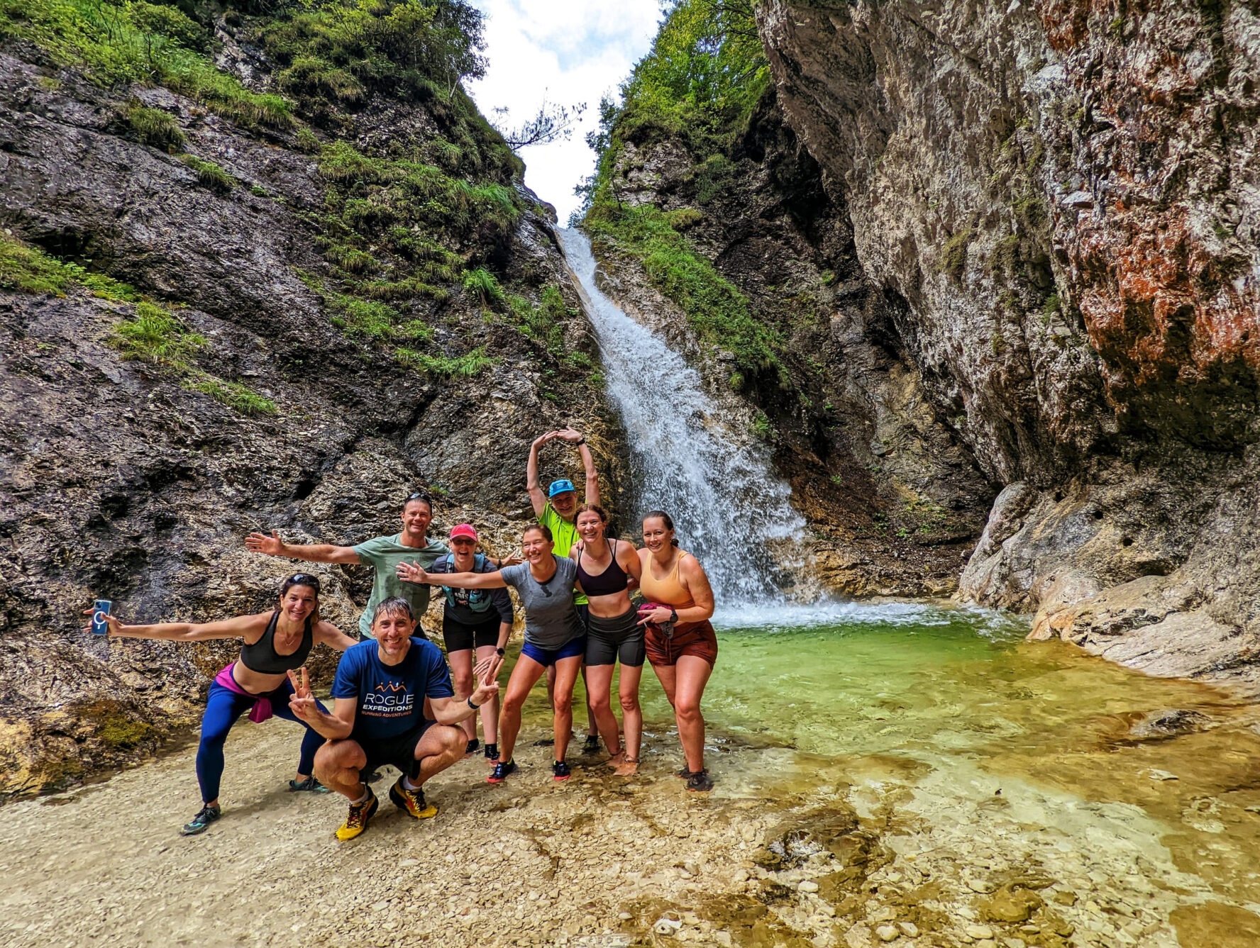 Runners next to a waterfall