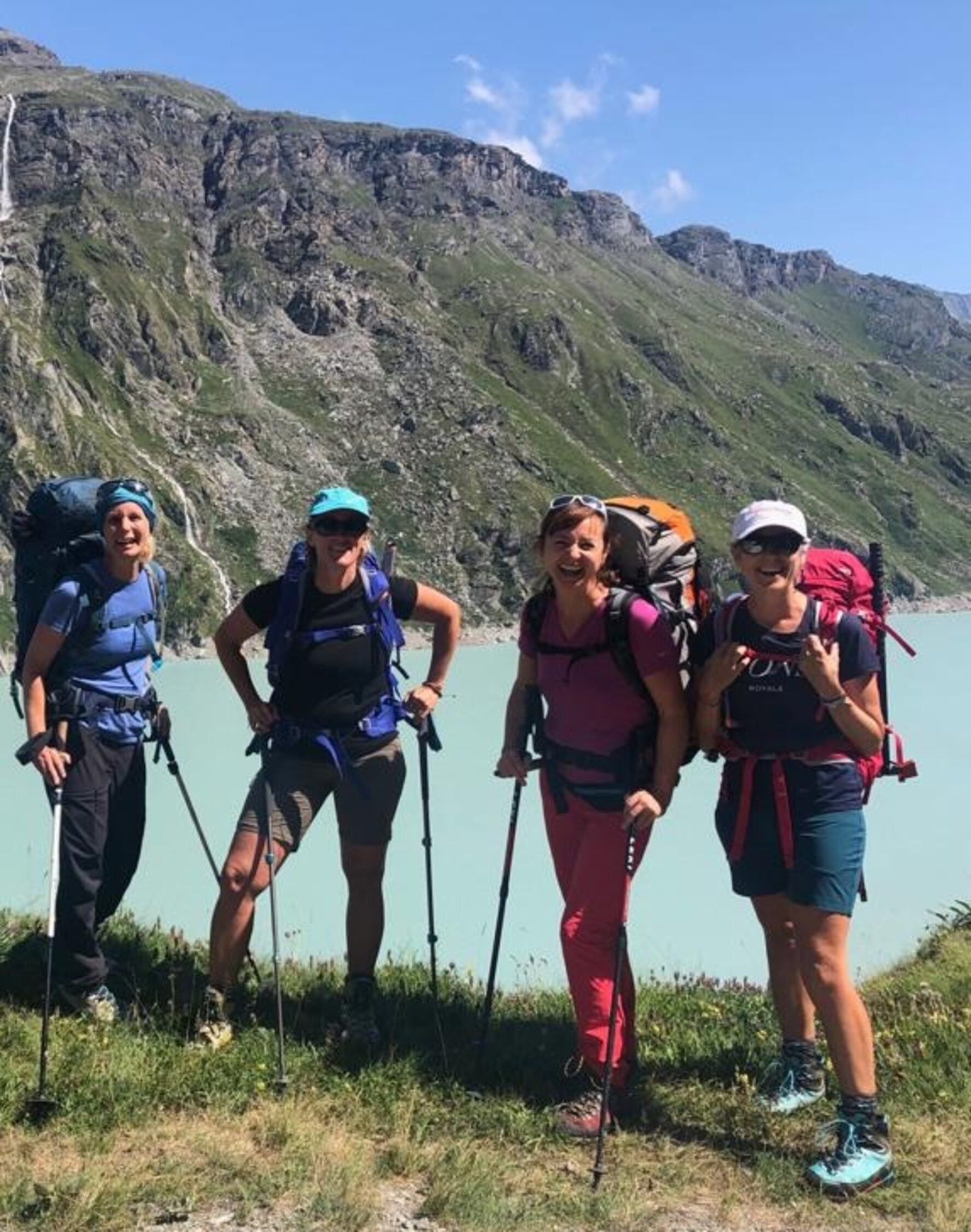 Women hiking and smiling in front of a lake near Zermatt