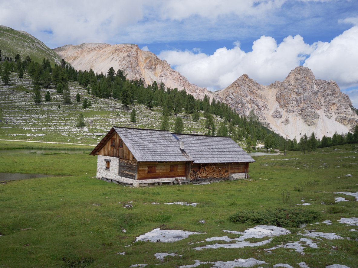 Wooden alpine hut in the Fanes-Sennes-Braies Natural Park with mountains in the background