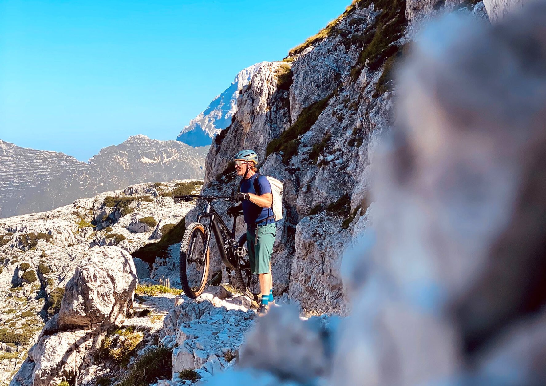 Cyclist standing on rocky terrain