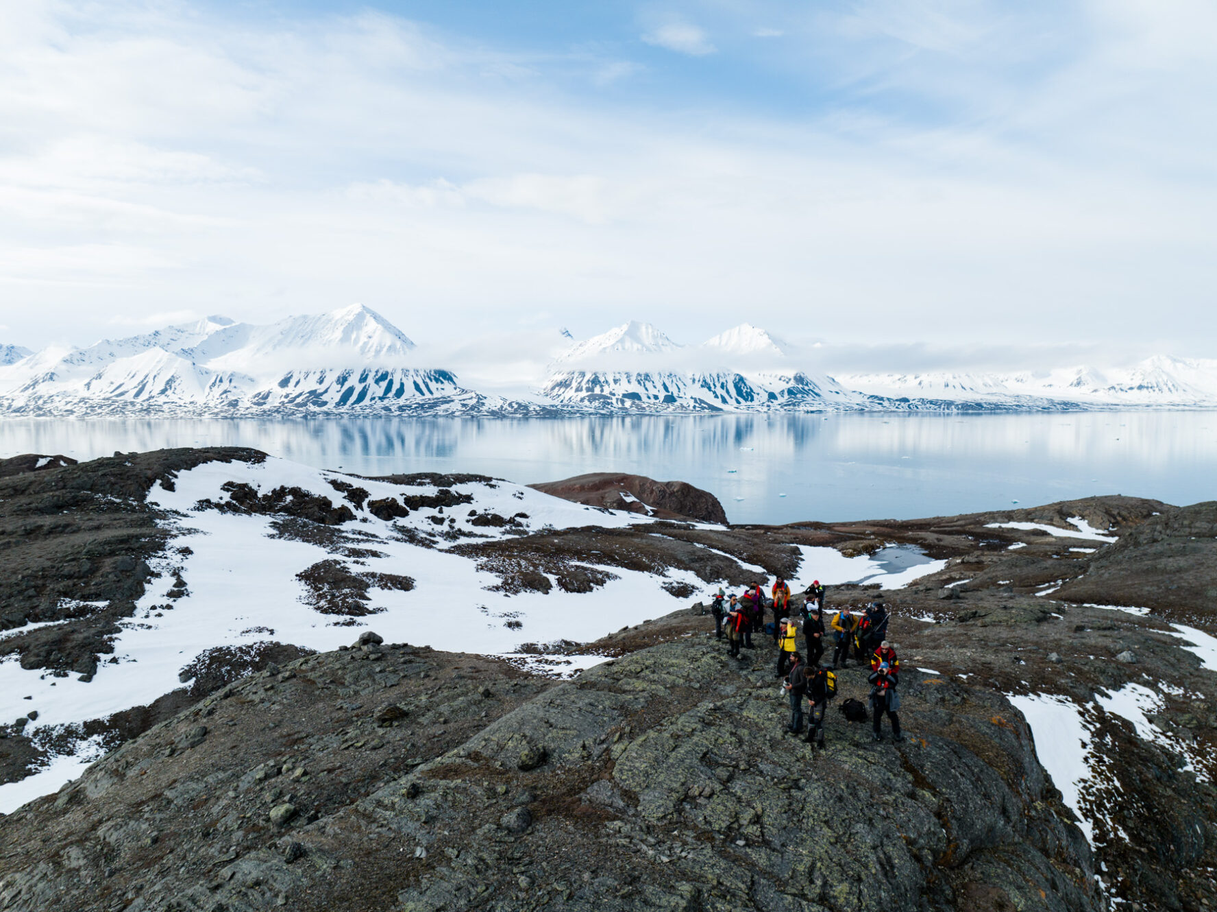 Adventurers exploring Svalbard with a view of the sea and mountains