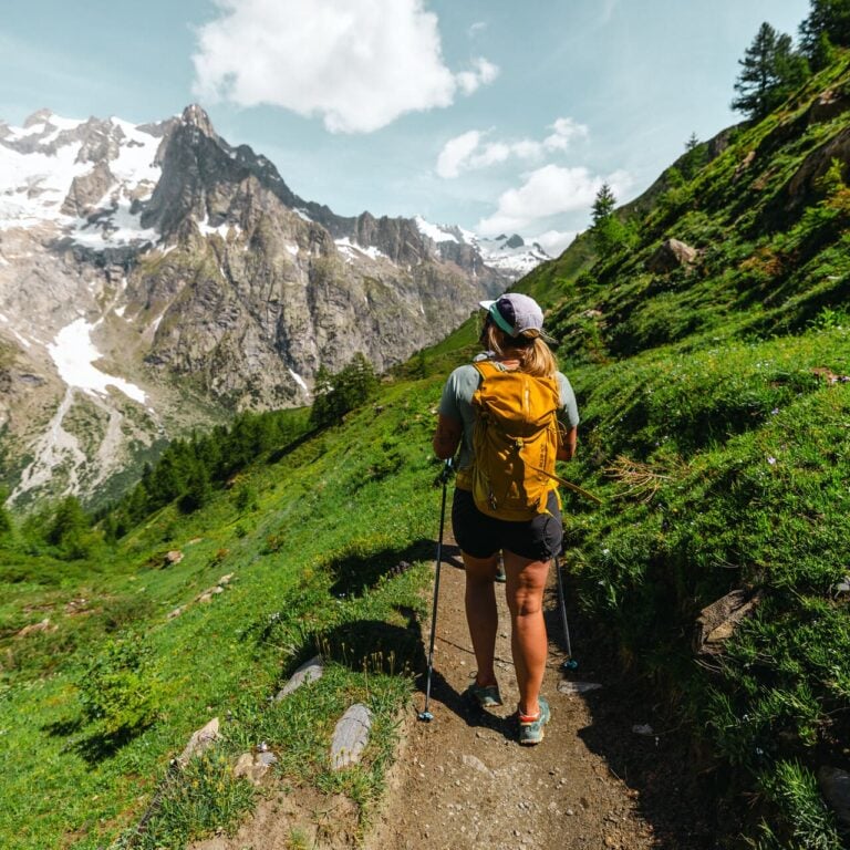 Hiker with a yellow backpack on a mountain trail