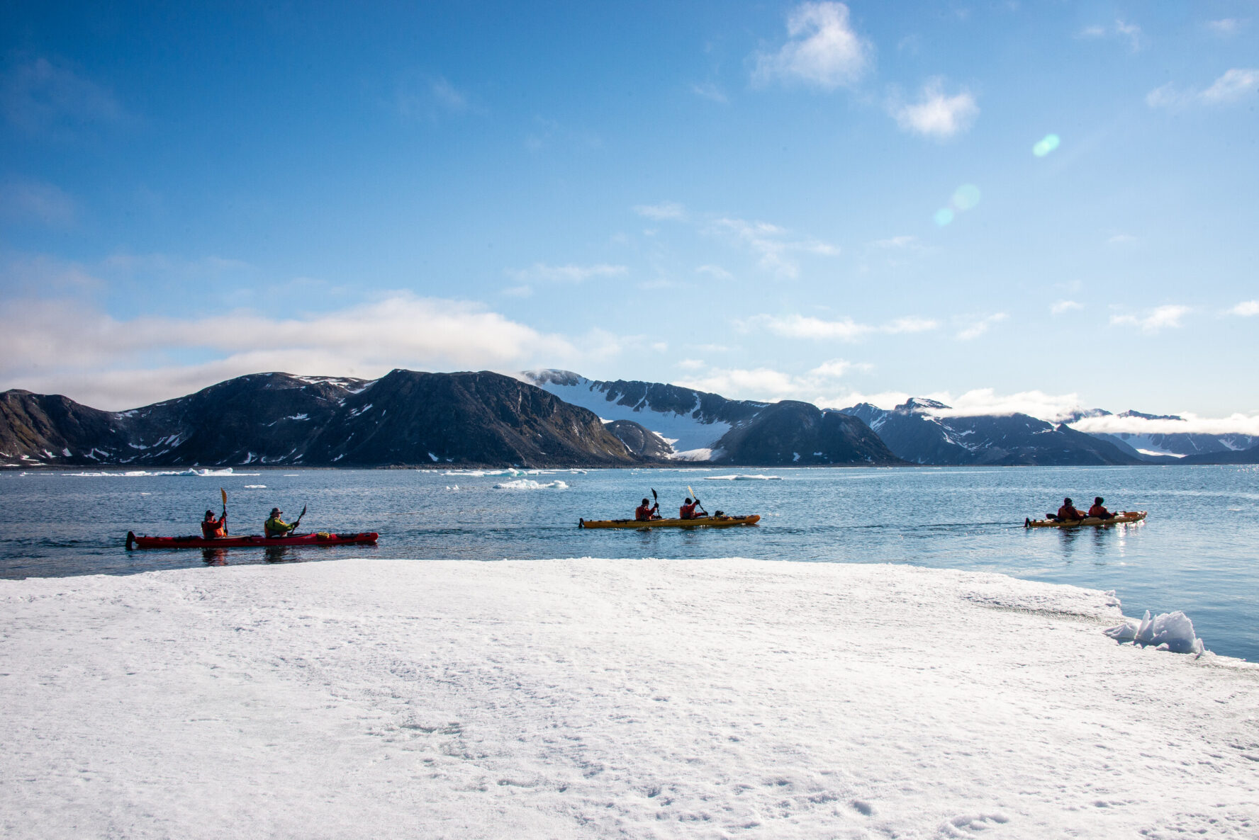 Kayakers in Svalbard with mountain backdrop