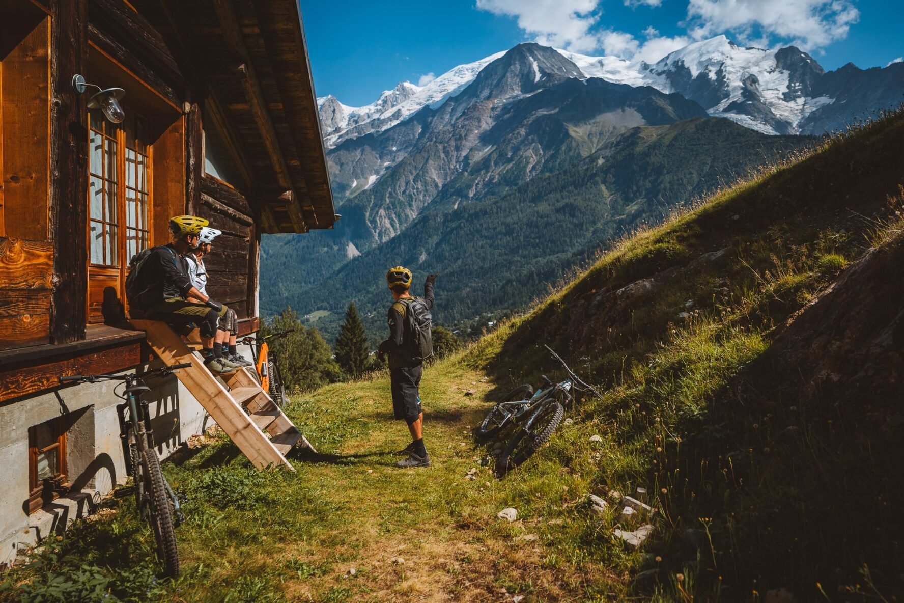 Riders talking near a hut in the Alps