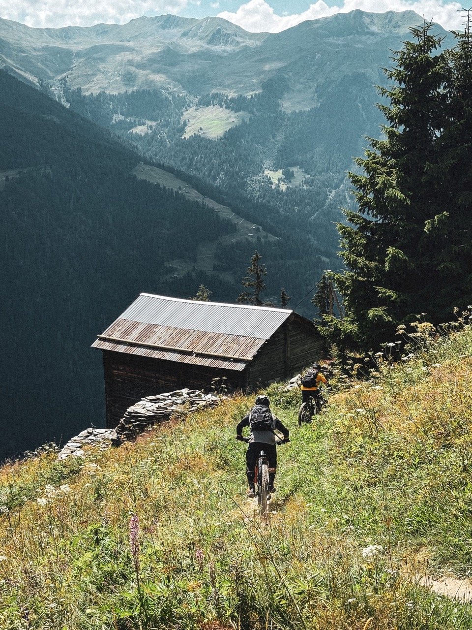 Riding past a hut in the Swiss Alps