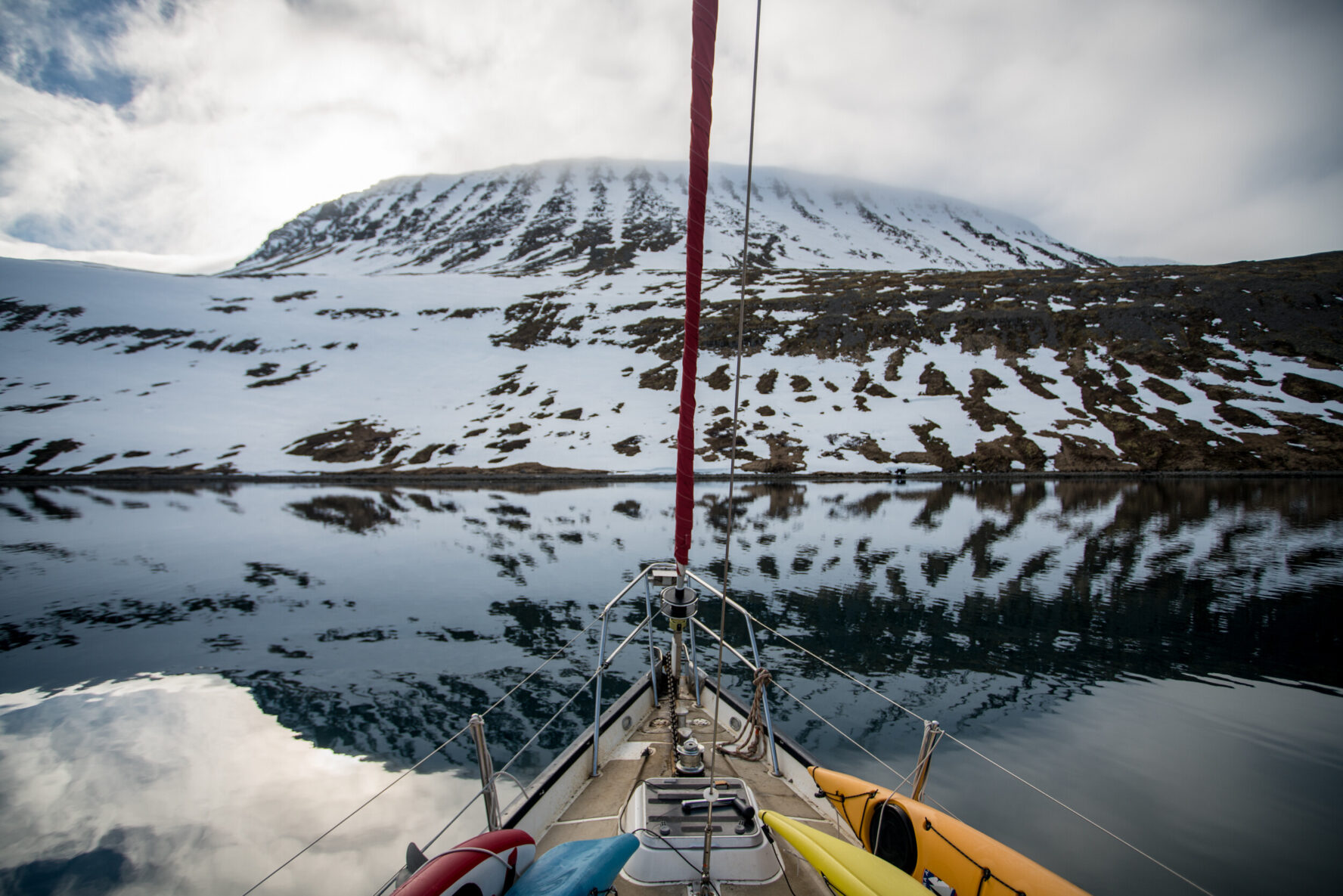 The sailboat facing a snowy mountain