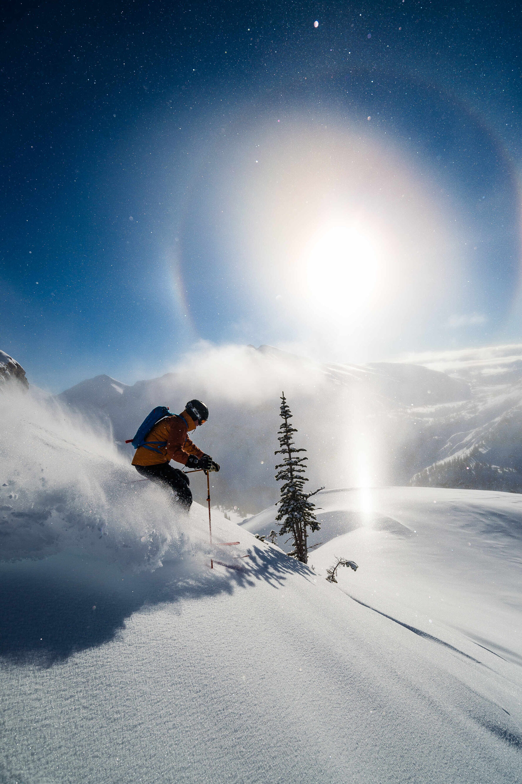 Skier in action on a snowy slope with sun halo