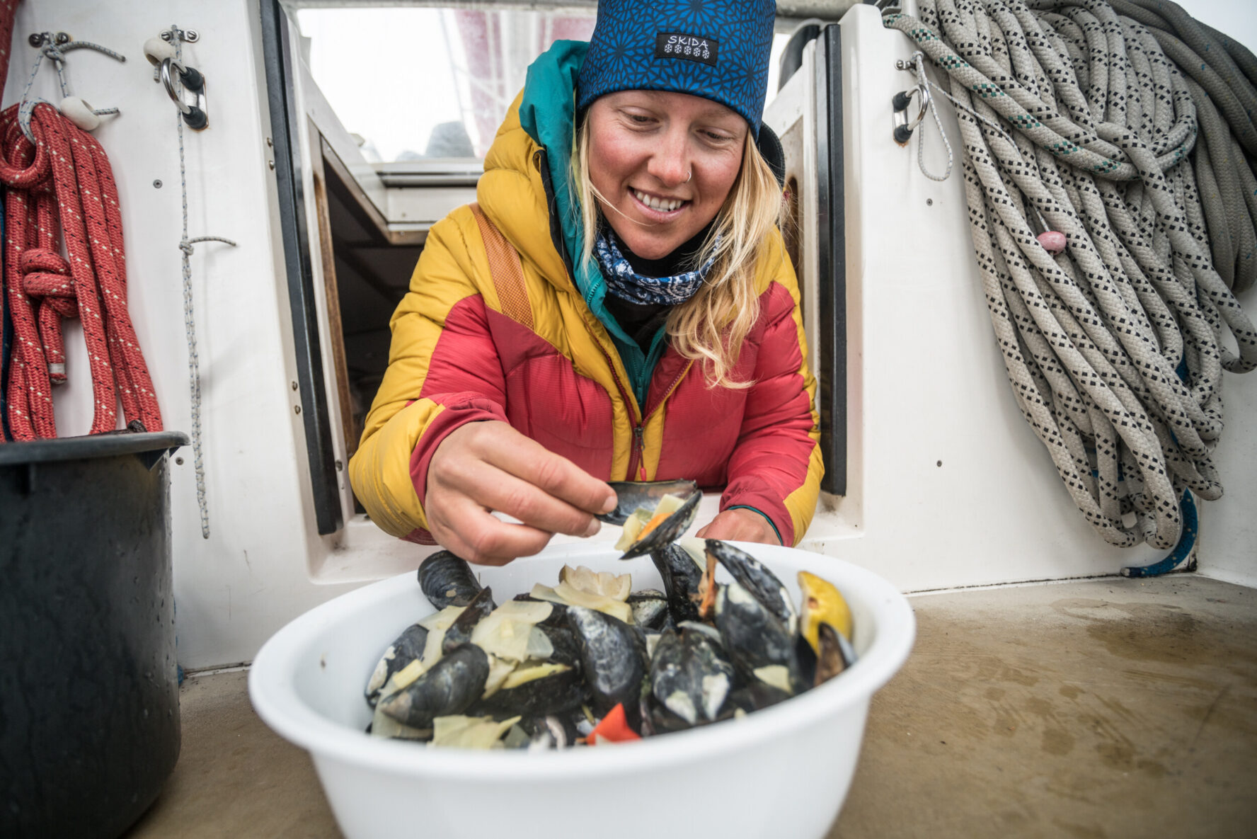 Skier tasting mussels aboard the sailboat