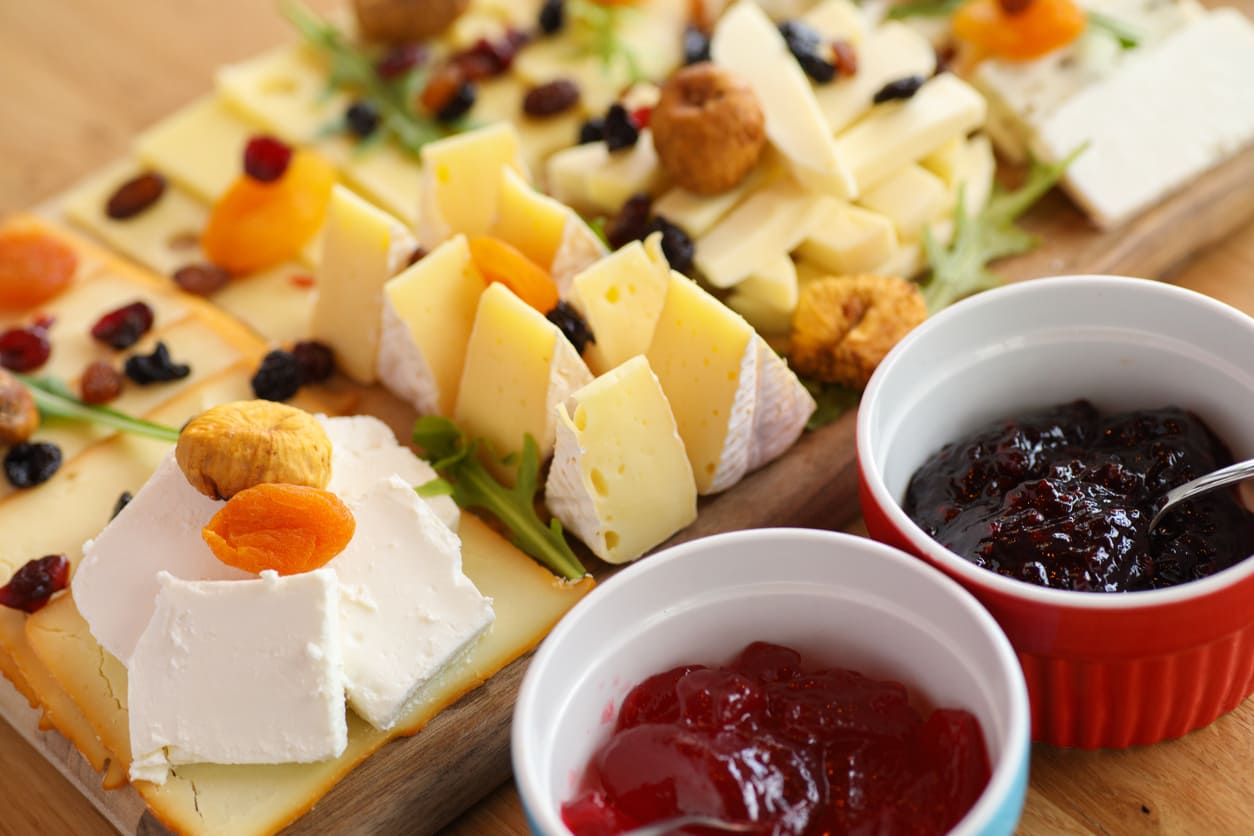 Cheese tasting with different varieties, jam, and dried fruit