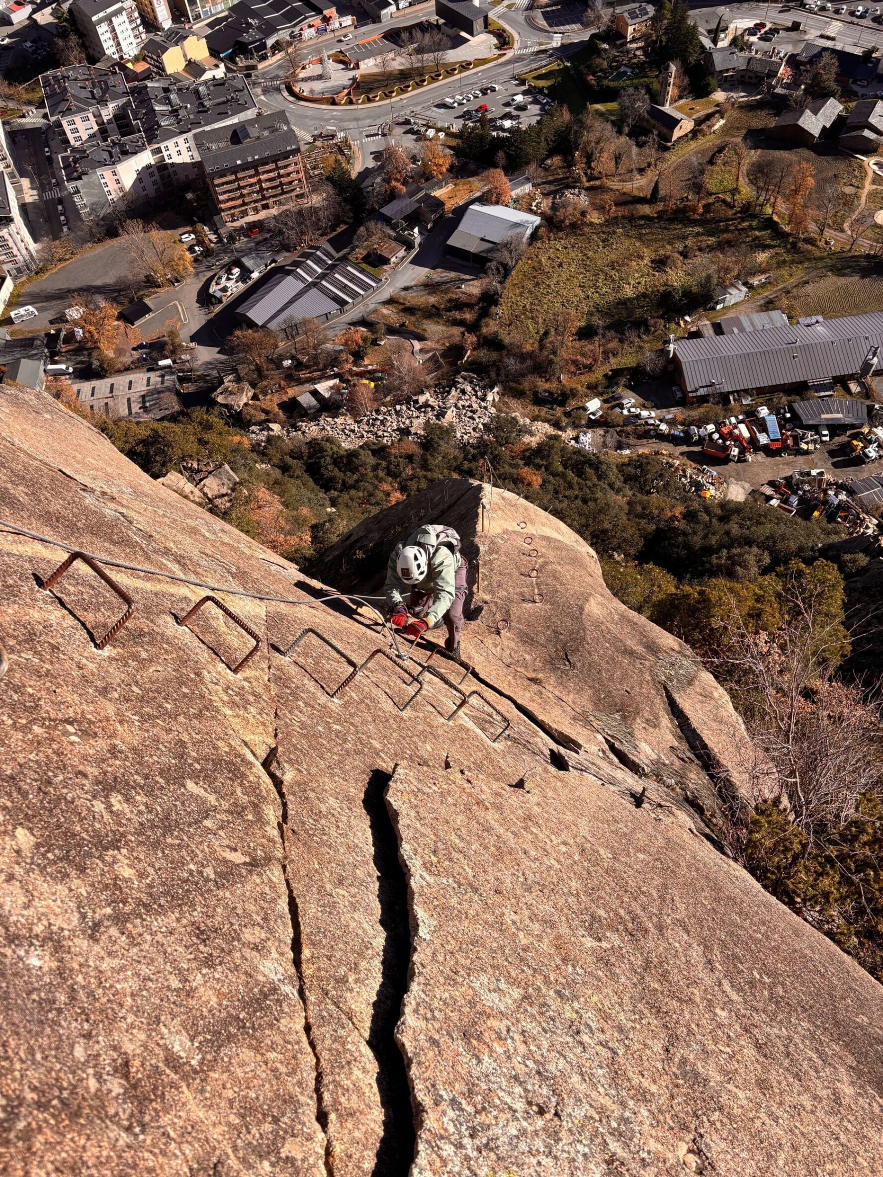 Climber above an urban area on the via ferrata in Andorra