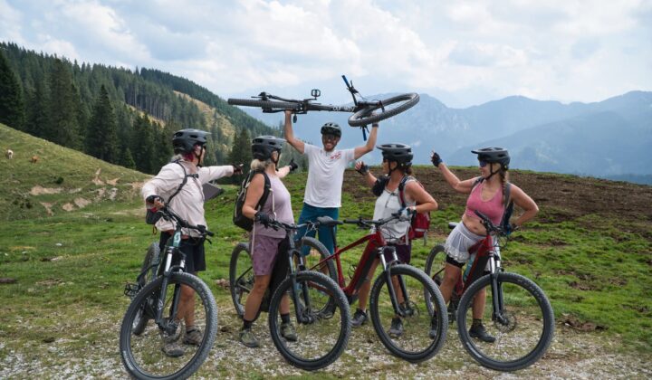 Five bikers pause on a mountain trail while e-MTB Julian Alps