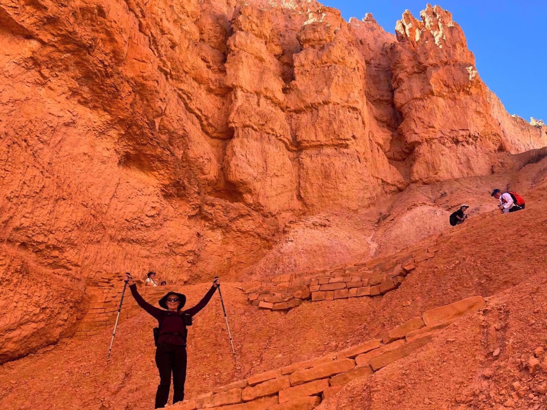Hiker in a landscape of red rocks on the Zion and Bryce hiking tour