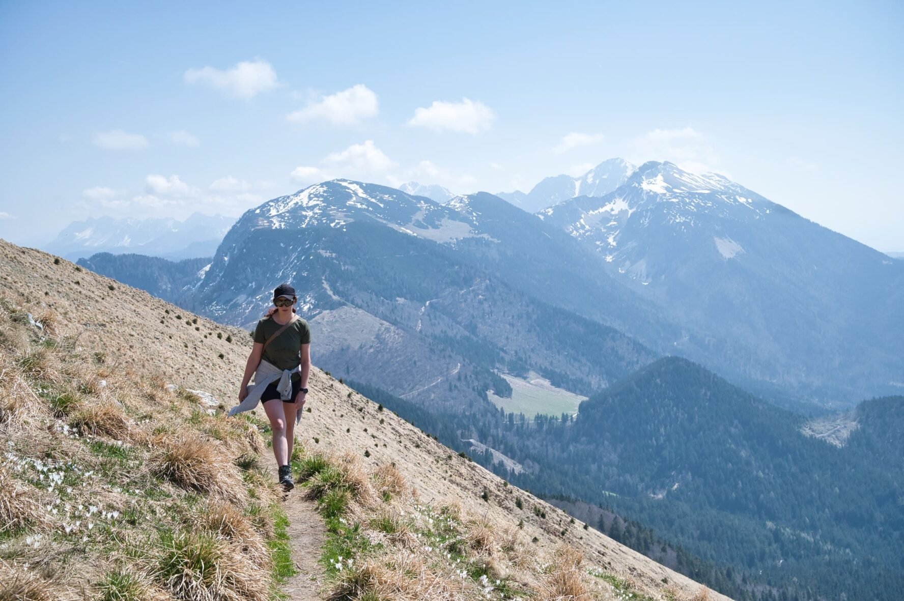 Hiker on a trail overlooking valleys and mountains in Slovenia