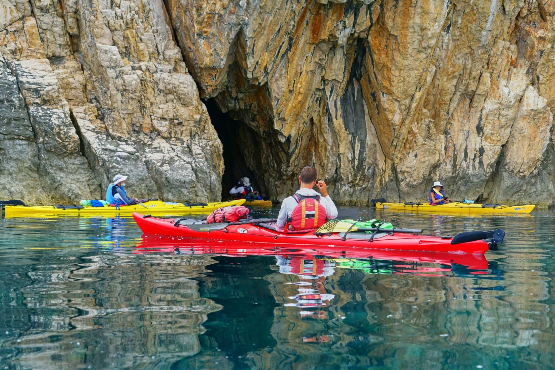 Kayakers in front of the cave entrance