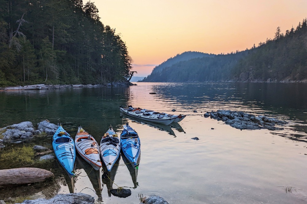 Kayaks in the water at sunset in Desolation Sound