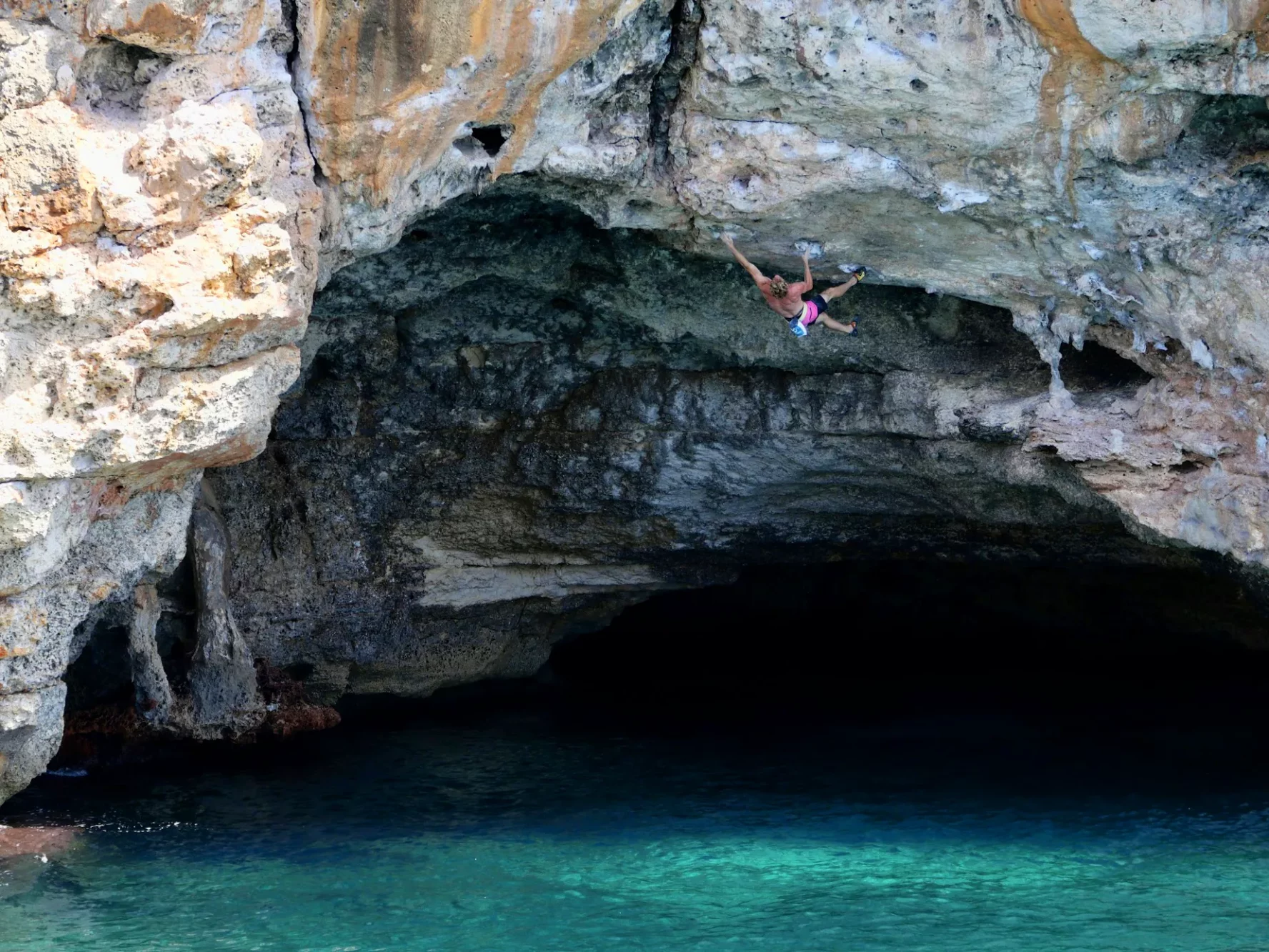 A climber doing deep water solo climbing in Mallorca, Spain