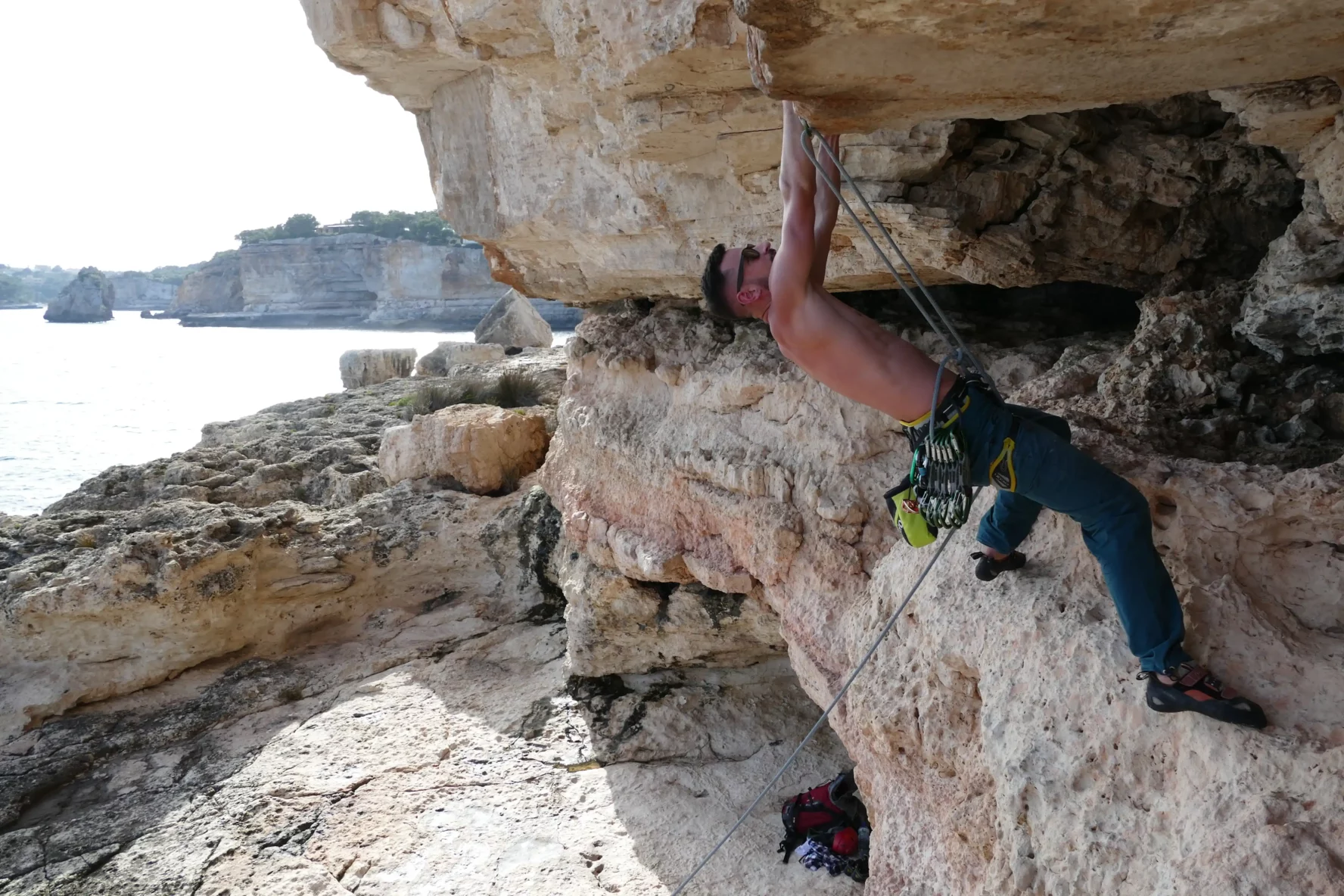 A climber on an overhead wall in the sun in Mallorca, Spain