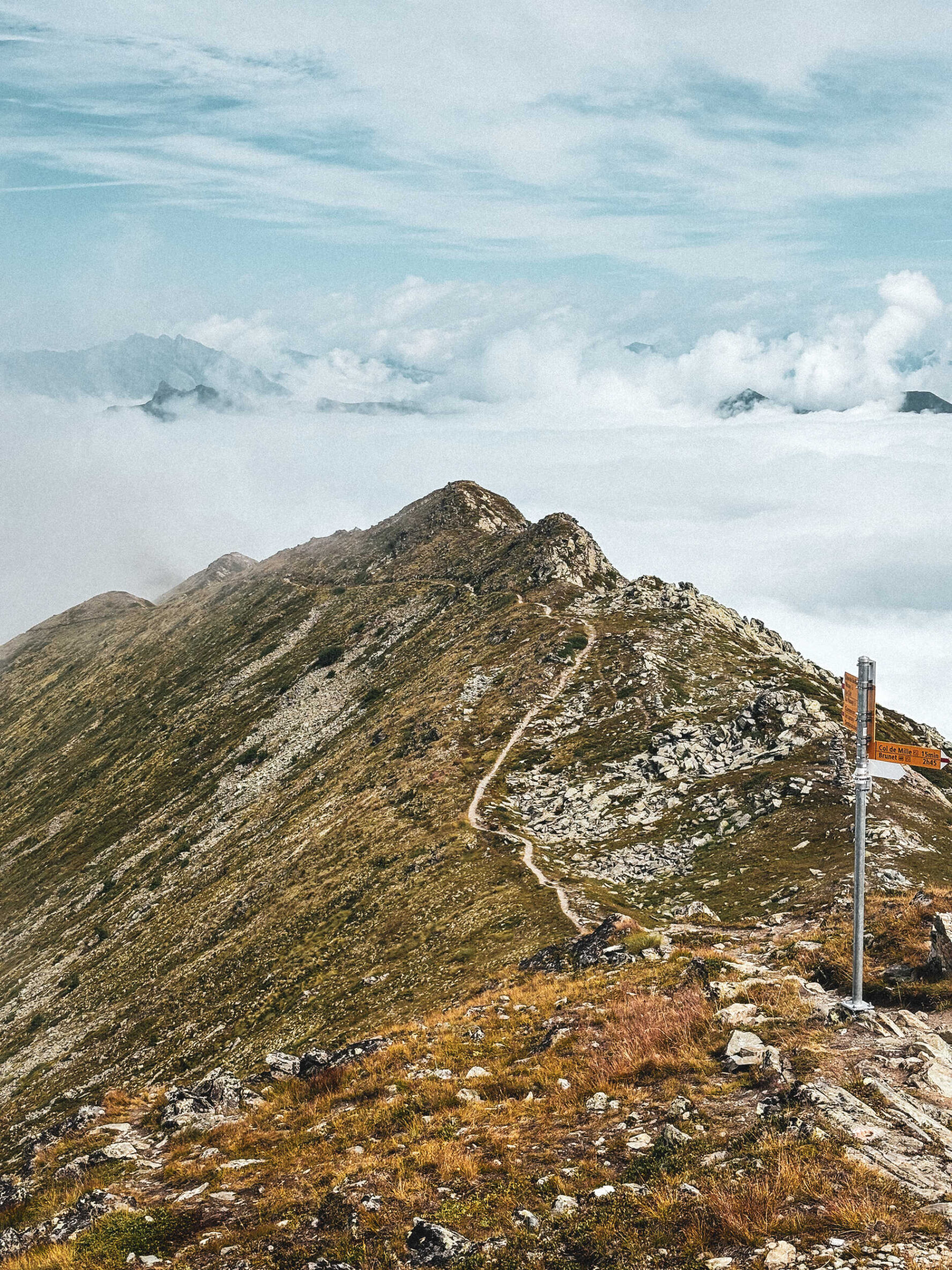 Mountain ridge trail and signpost in Valais