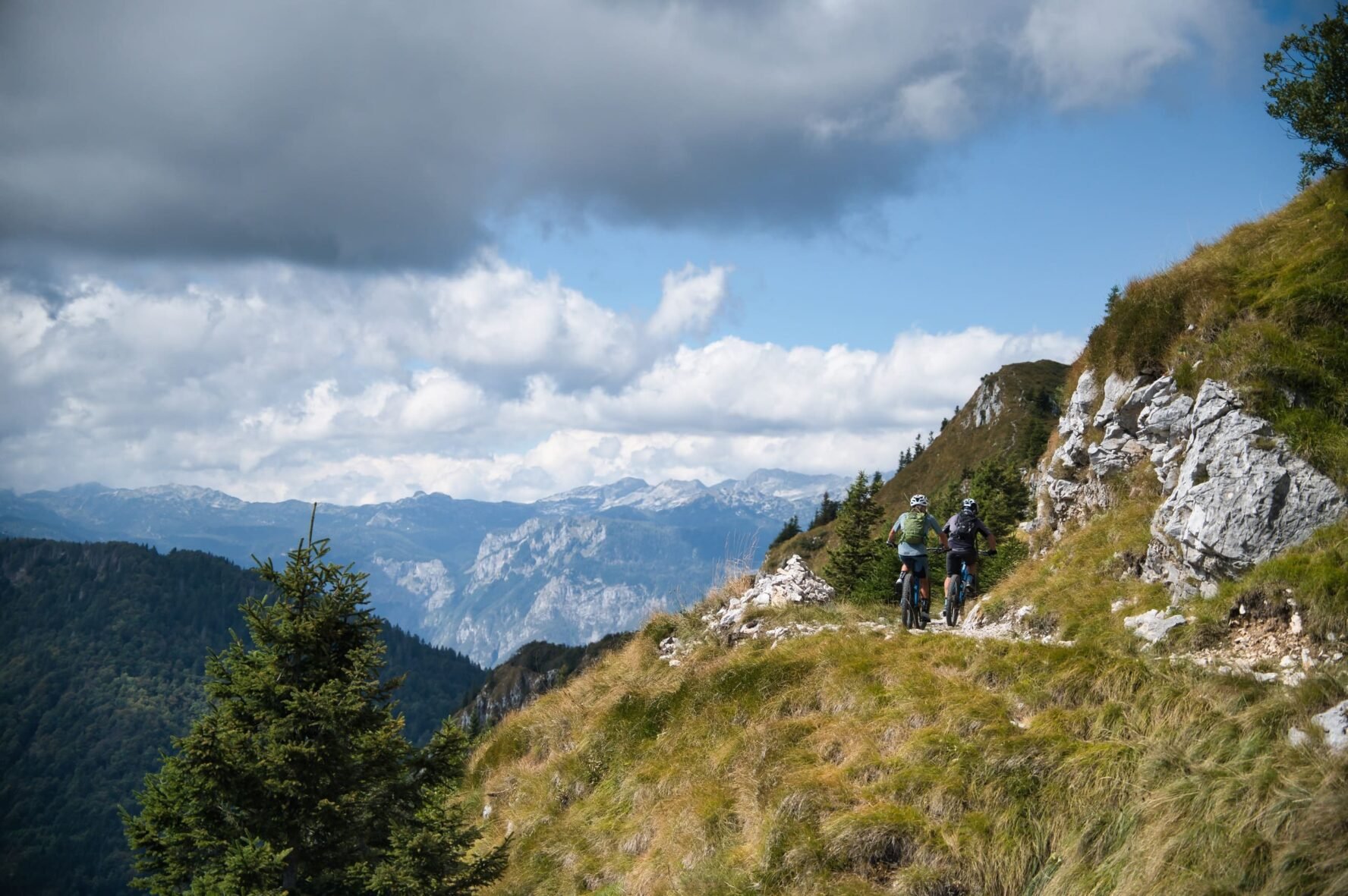 Two cyclists ascending a mountain trail in the Julian Alps