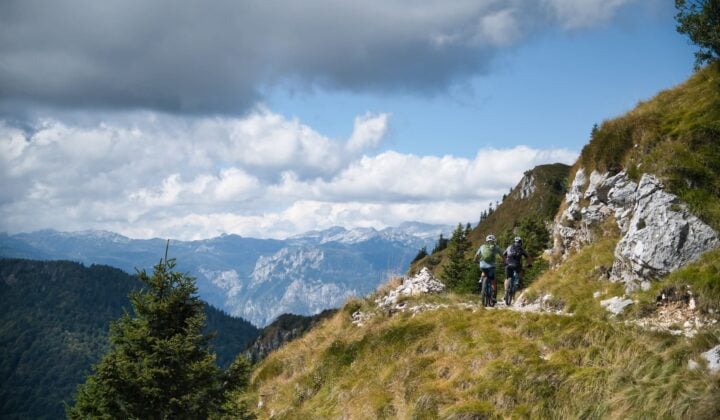 Two cyclists ascending a mountain trail in the Julian Alps
