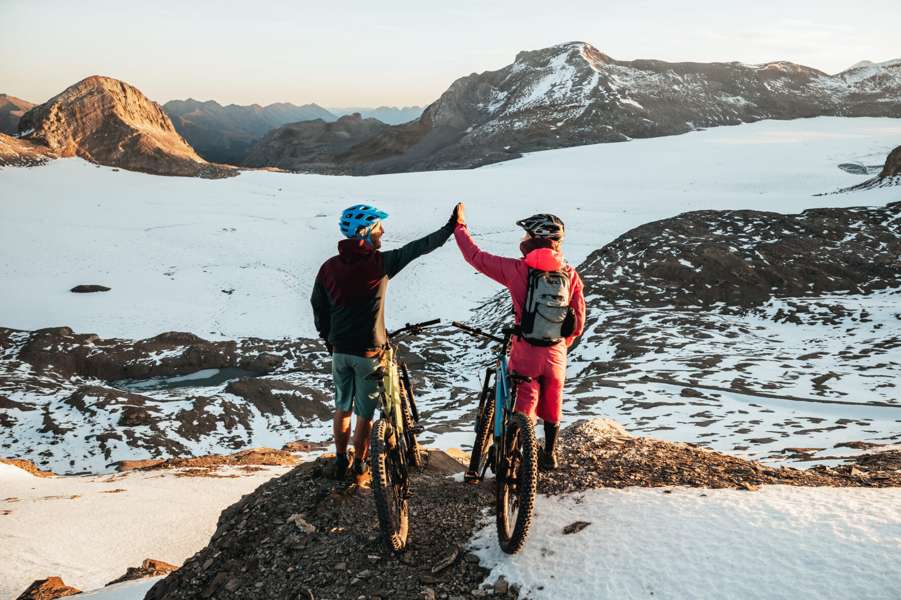 Two MTBers high fiving in the Alps