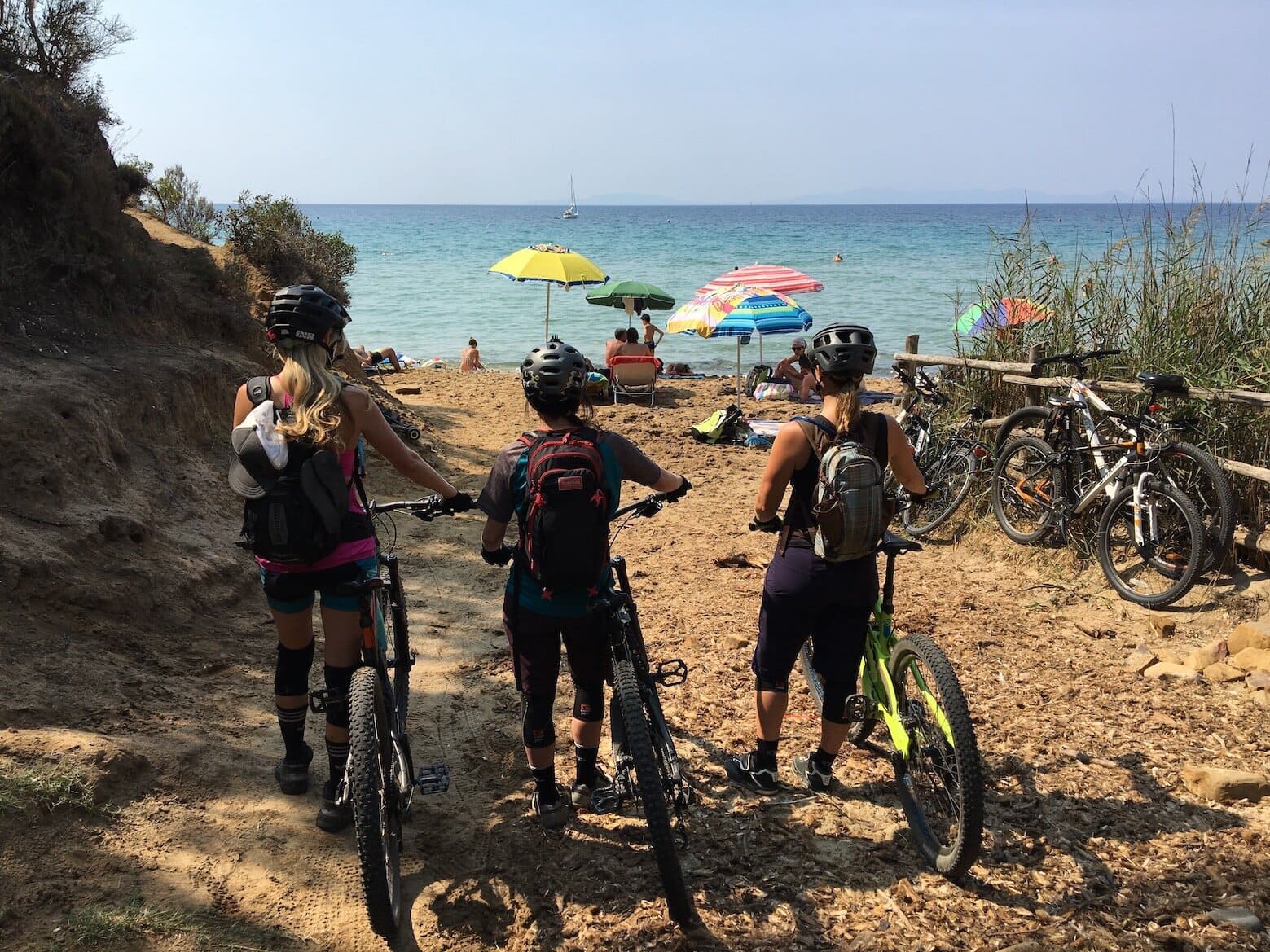 Bikers on a sandy beach during this Tuscany e-bike trip