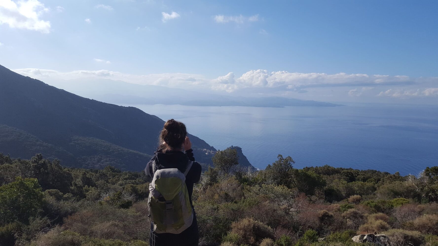Hiker on a hill with sea in the background