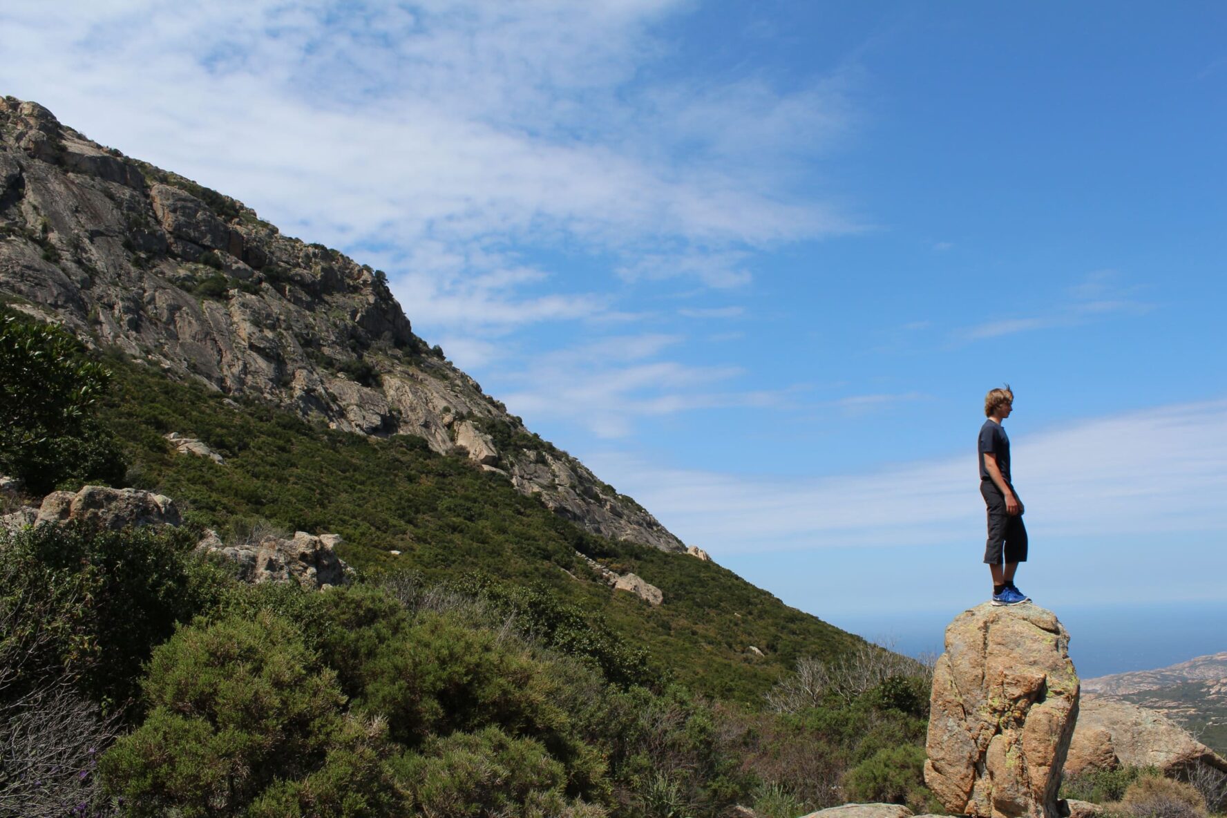 Hiker standing on a rock with mountains in the background