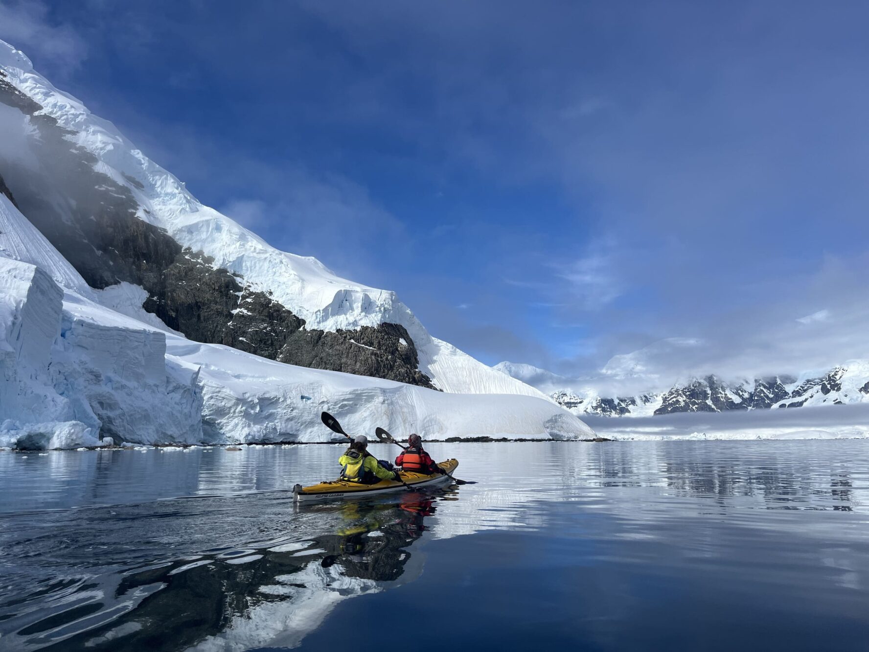 Kayaking next to a mountain and glaciers on the Antarctica adventure