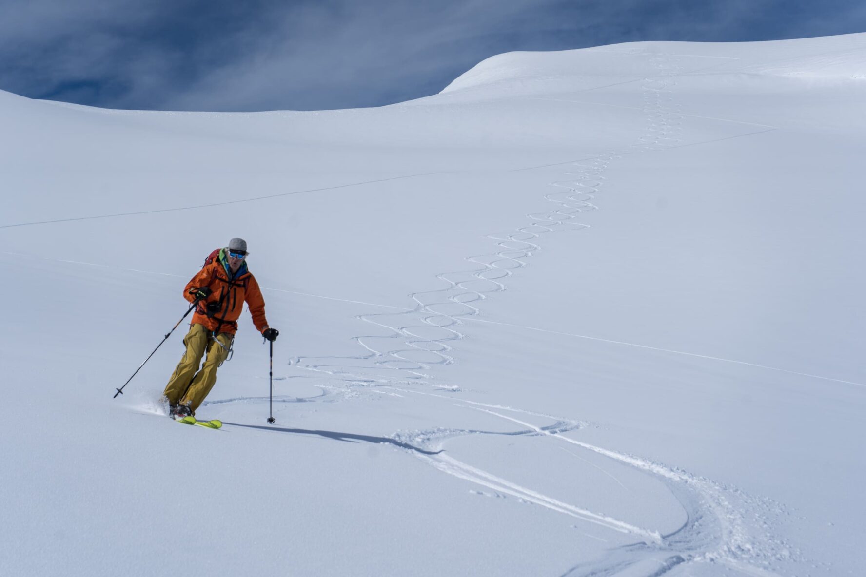 Skiing down a slope on the Antarctica adventure with tracks in the background