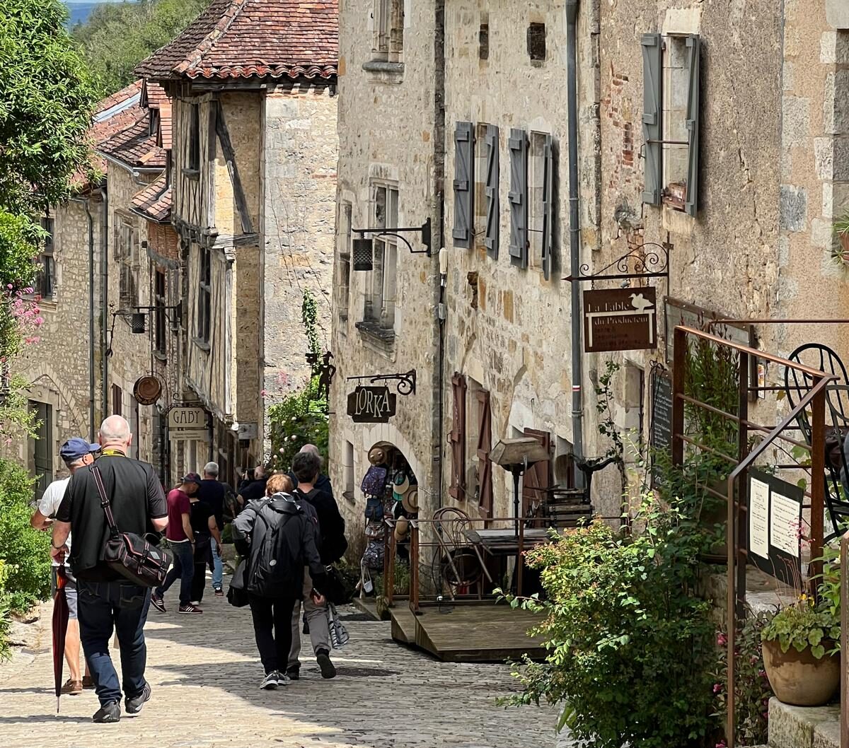 Hikers walking down a street in Saint-Cirq-Lapopie on the Le Puy Camino