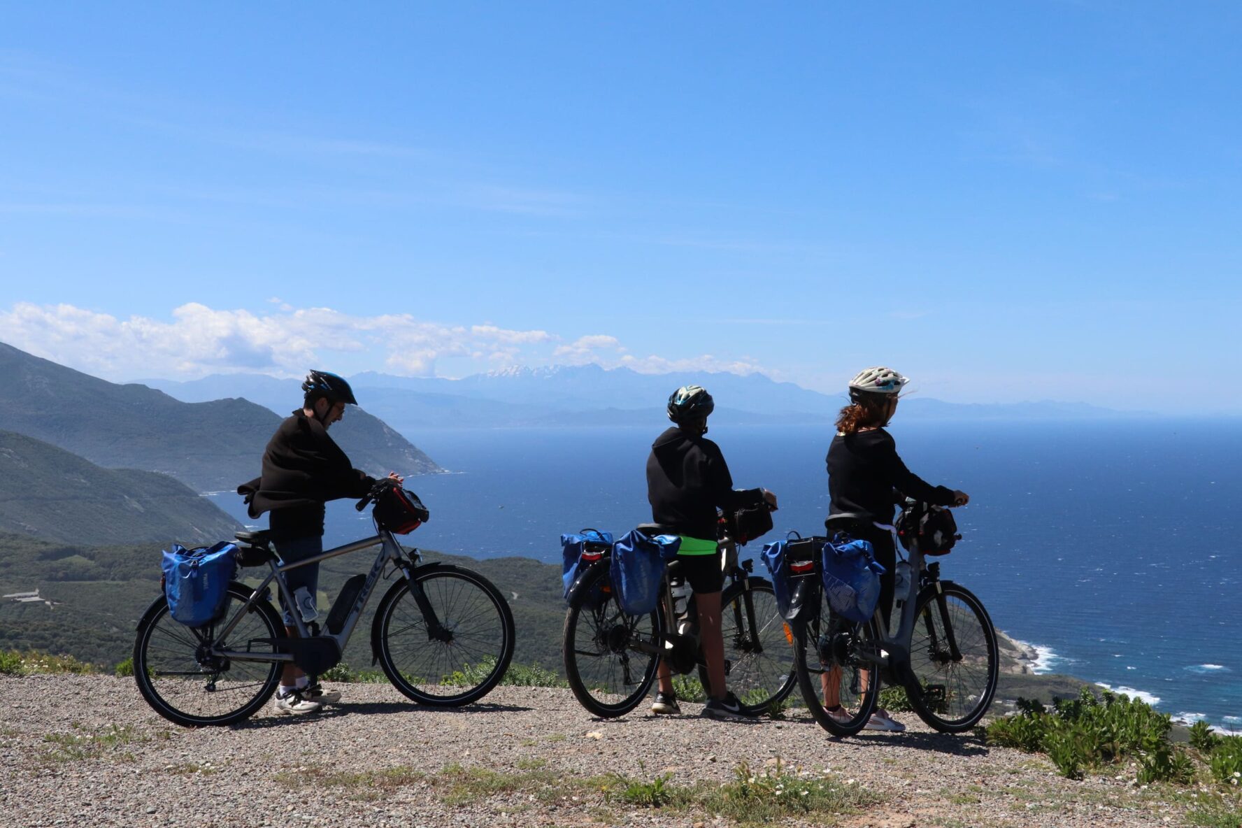 Three riders on a viewpoint with sea and mountains on the North Corsica bike holidays