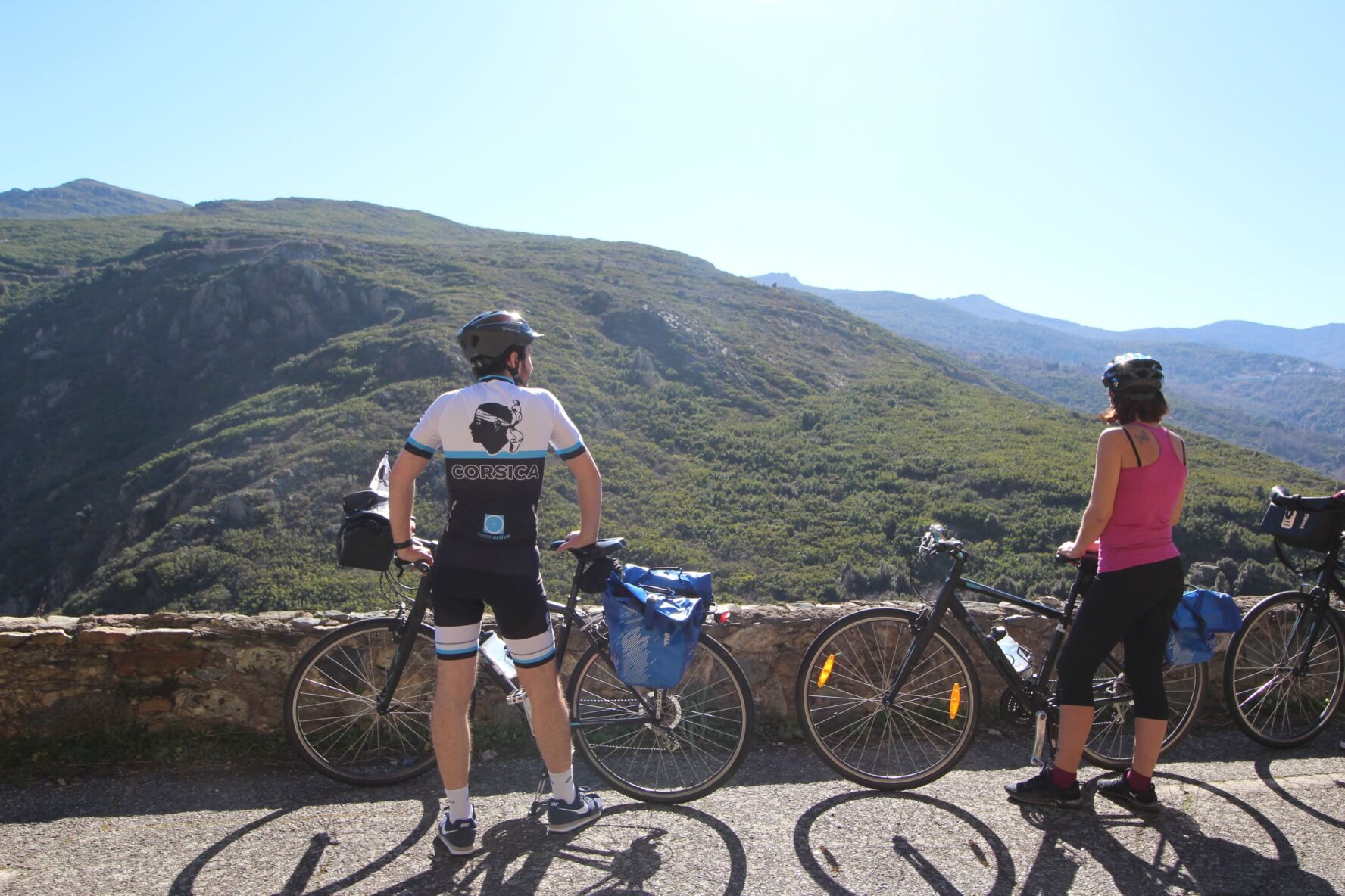 Two riders on a road overlooking mountains on the North Corsica bike holidays
