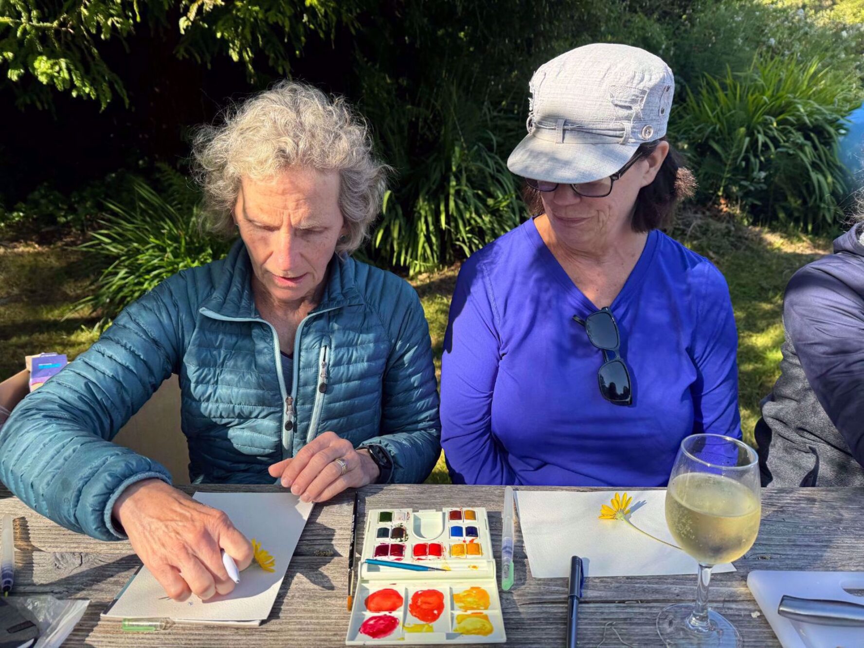 Two women painting and enjoying a glass of wine on the Redwood wellness tour