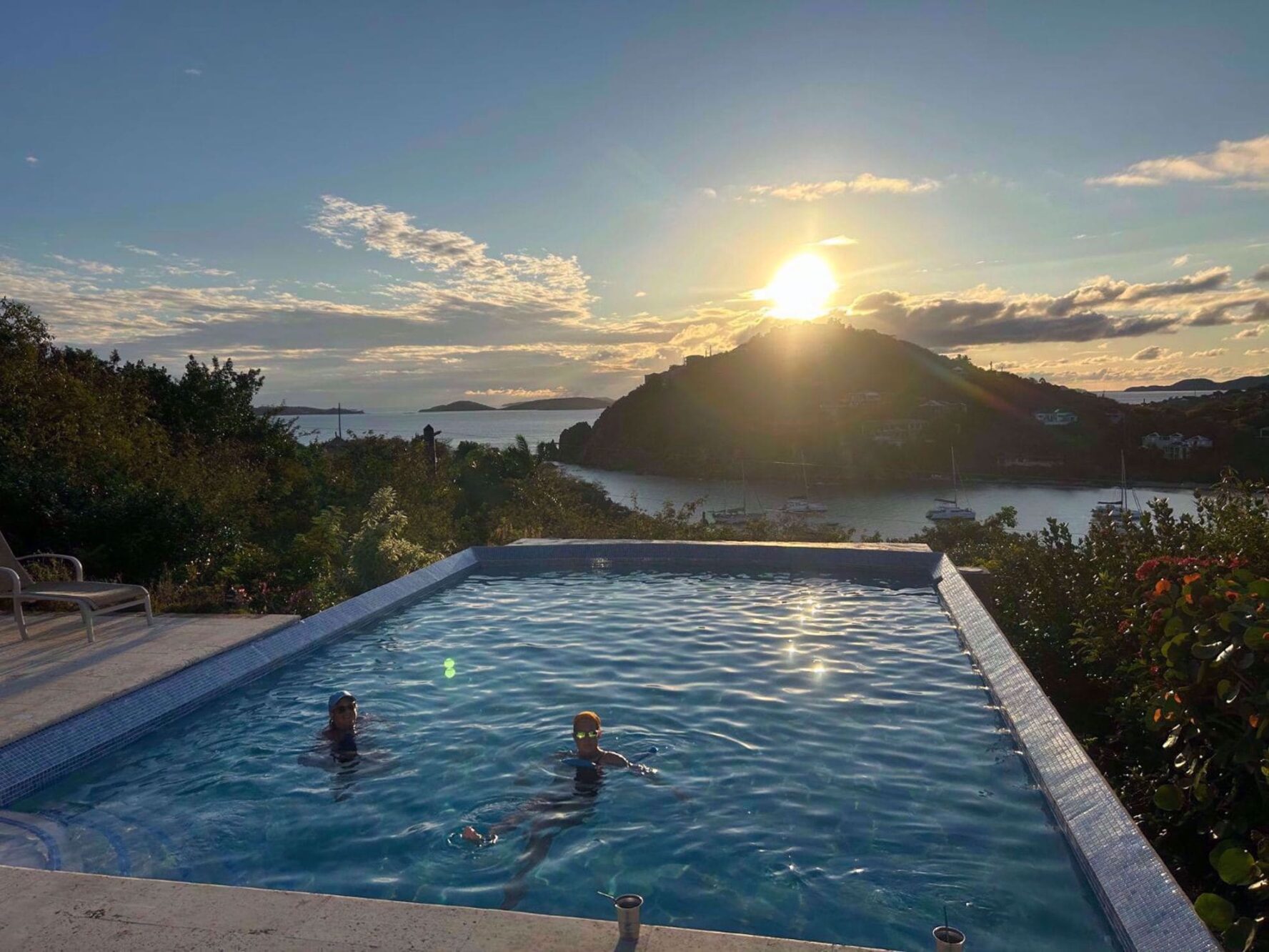 Women unwinding in the pool at the villa on St. John island at sunset