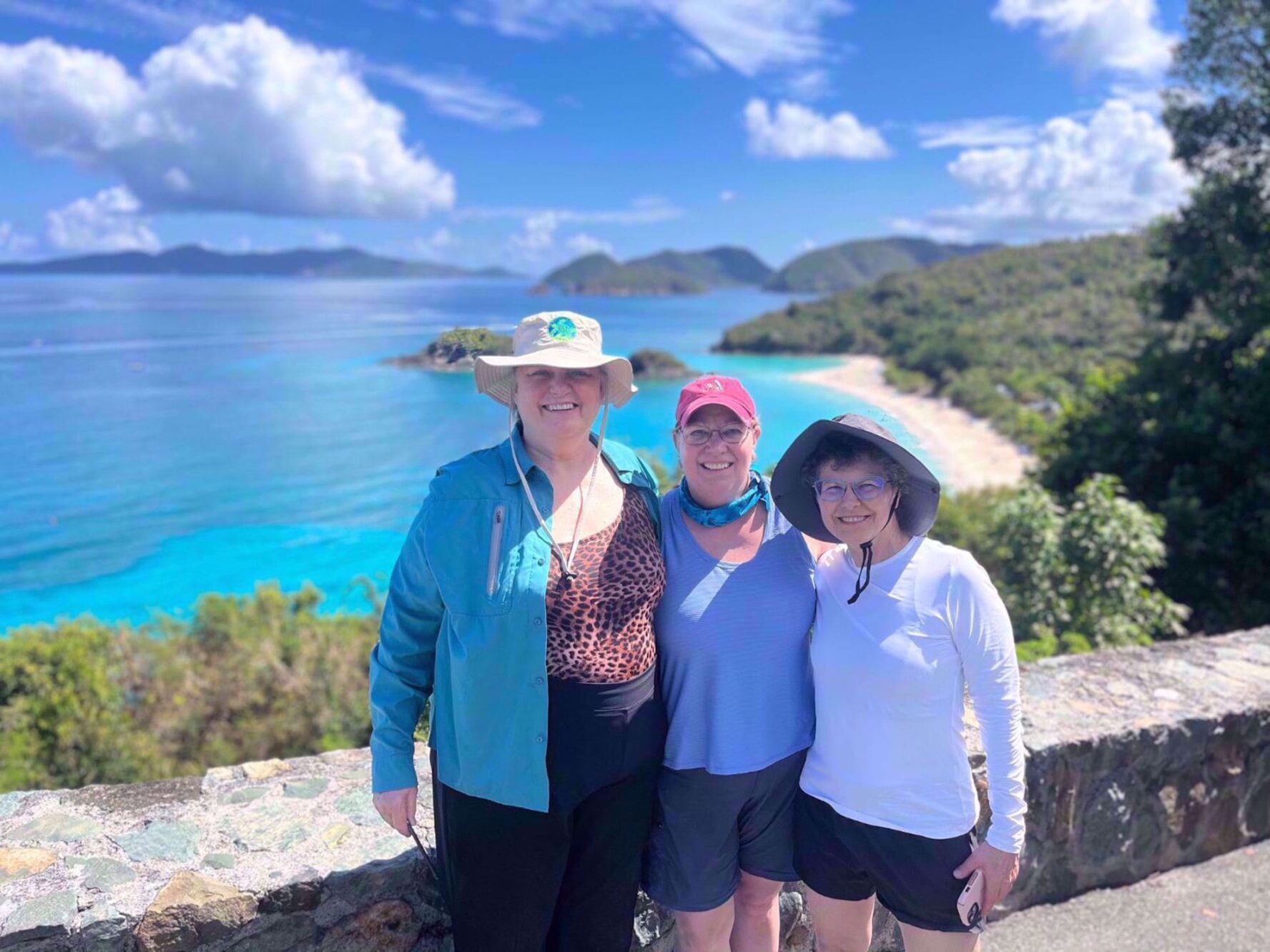 Women smiling on an overlook above Cinnamon Bay on their Caribbean adventure